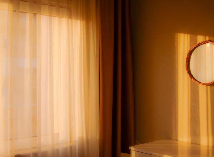 Soft morning sunbeams crossing a quiet yoga studio floor