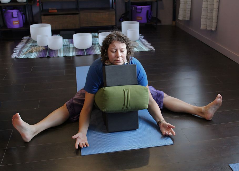 A restorative pose supported by a bolster and blanket